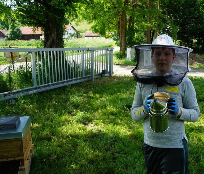 Junger Imker mit Schleier und Smoker